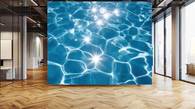 Bright blue swimming pool with shimmering water. The sunlight reflects on the rippled surface, creating a beautiful pattern of light and shadow on the clear water Wall mural