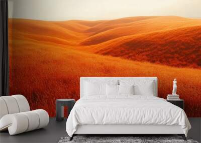 Bright orange grass meadow with gentle hills basking in warm sunlight creating a serene nature scene Wall mural