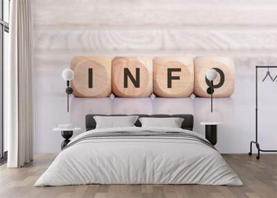 the word info is written on a wooden blocks structure. Blocks on a bright gray background. Selective focus. Wall mural