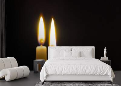 two burning candles on a black background Wall mural