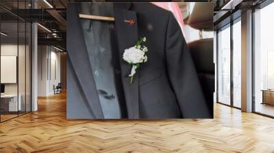 A man who is dressed in a formal suit has a vibrant flower carefully placed in the pocket of his jacket, adding a touch of elegance Wall mural