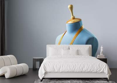 Blue tailor dummy with measuring tape alongside the wall. Wall mural