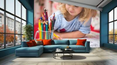 Portrait of child girl drawing with colorful pencils Wall mural