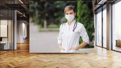 Female doctor or nurse wearing a face protective mask Covid19 healthcare concept Wall mural