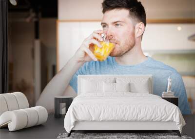 man drinking orange juice Wall mural