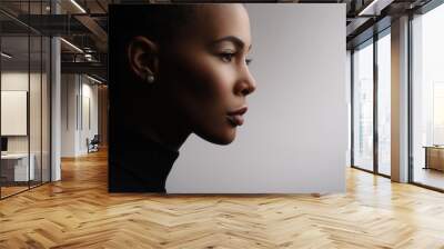 Closeup fashionable portrait of a metis young woman with perfect smooth glowing skin, full lips, collected hair and long neck. Studio photo of an african american female model face, profile Wall mural