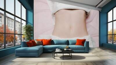  Belly of a young European woman on a massage bed. Preparation for procedures. Professional abdominal massage. Top view Wall mural