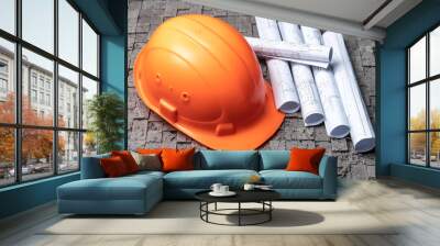 Orange worker helmet on grey wall background Wall mural