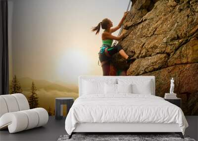 Beautiful Woman Climbing on the Rock at Foggy Sunset in the Mountains. Adventure and Extreme Sport Concept Wall mural