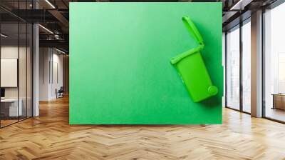 Trash bin. Green dustbin for recycle glass can trash isolated on green background. Container for disposal garbage waste and save environment. Wall mural