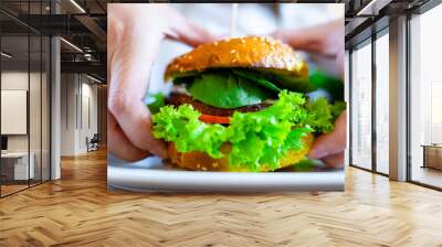 Vegan sandwich healthy vegetarian burger. Cute cheerful girl eating veggie hamburger with salad, avocado, vegetable. Vegetarian diet food concept. Wall mural