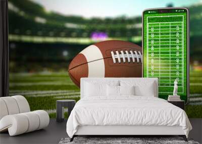 American football app video game on smartphone and betting sport online concept. Mobile phone and american football ball. Wall mural