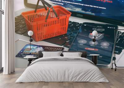 Mobile phone, shopping basket and credit card on laptop keyboard Wall mural