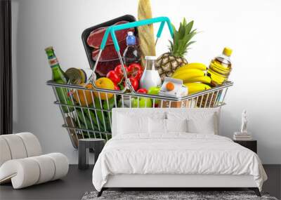 Shopping basket full of variety of grocery products, food and drink isolated on white background. Wall mural