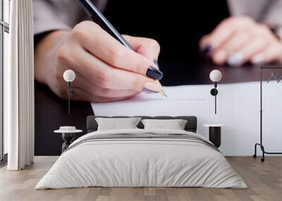 Close up girl hand putting signature on document. She situating at desk. Business concept. Low angle Wall mural