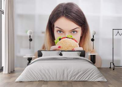 Diet. Young woman with duct tape over her mouth, preventing her to eat junk food. Healthy eating concept Wall mural