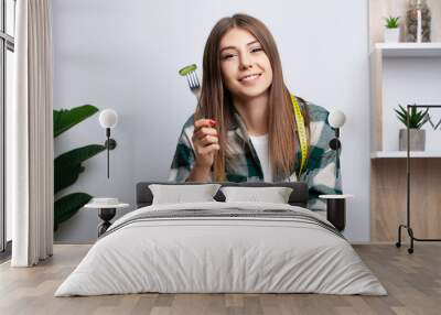 Girl eats vegetable salad with lots of vitamins Wall mural