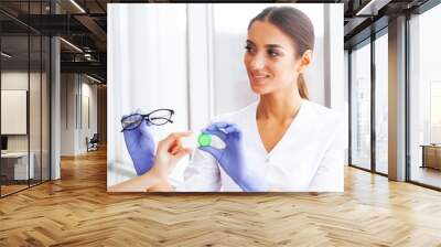 Vision concept. Eye doctor choosing between eyeglasses and lenses standing in front of the eye chart in the cabinet Wall mural