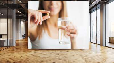 Vitamins and Supplements. Woman taking a tablet. Close up hand with a pill and the mouth. Wall mural