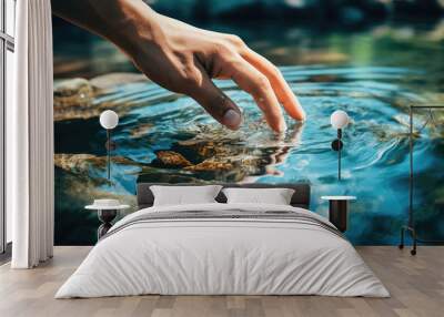 Woman's hand touching water in the midst of nature Wall mural