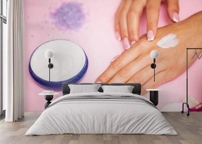 Woman applying hand cream at home, closeup Wall mural