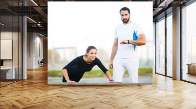 Woman training with personal trainer at park Wall mural