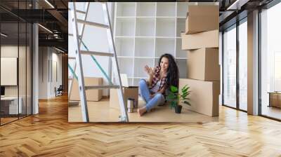 Young woman dropping cardboard box. Moving into new home Wall mural