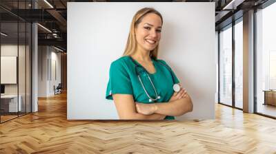 Female nurse standing arms crossed. Confident young woman doctor. Female nurse, young pretty woman in green clothes smiling Wall mural