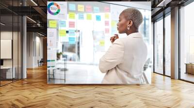 Black woman, thinking and glass board for project management, marketing or planning at office. African female person, manager or employee checking project plan, tasks or statistics at the workplace Wall mural