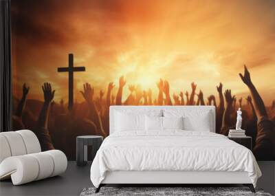 Hands silhouettes of a crowd raised up to worship God against a sunset sky Wall mural