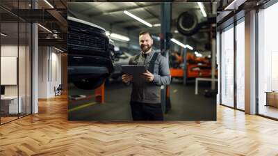 Professional portrait, mechanic or man working on vehicle or car engine in engineer or garage workshop. Confident, male or smiling and using tablet for car service repair and engineer Wall mural