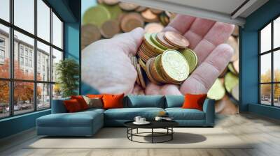 Euro cent coins in hand. Woman hand holding money. Saving for future concept. Wall mural