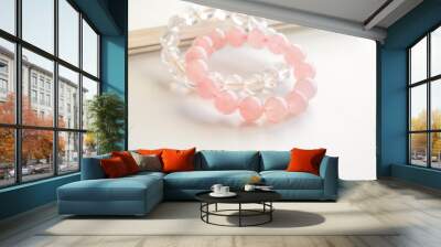 Rose quartz crystal bracelet and clear quartz bracelet on the table. Pink stone for healing and protection. Jewellery fashion design.   Wall mural