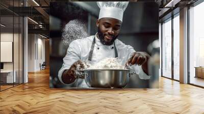 Black man chief cooks cakes. Baker adds some dry fruits in flour inside metallic pot to mix it and make cake batter in his professional artisan confectionery   Wall mural