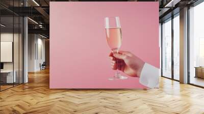 cropped shot of man cheering by champagne glass isolated on pink background Wall mural