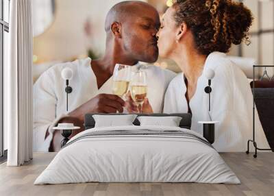 Black couple kiss at spa for wellness, champagne and love with romance for stress relief, celebration of relationship and bonding. Black man, black woman and anniversary getaway, toast with drink. Wall mural