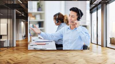 Happy, confident and helpful call centre agent talking on a headset while working on computer in an office. Salesman or consultant operating a help desk for customer care and service support Wall mural