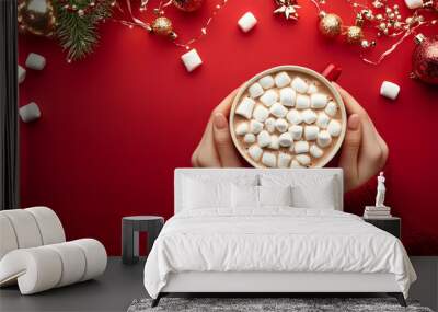 Female hands holding cup of hot chocolate with marshmallow on isolated red background with Xmas decoration, top view. New year eve party. Food and drinks concept. Christmas table.    Wall mural