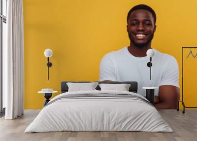 Happy young black man in casual attire arms crossed pose on yellow background Wall mural