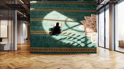 A Muslim woman praying inside the mosque. Wall mural