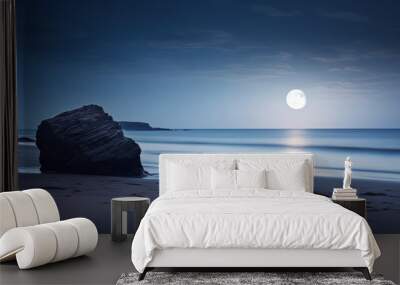 The peacefulness of a beach captured in a long exposure, with a rock standing under the soft light of a moonlit night Wall mural