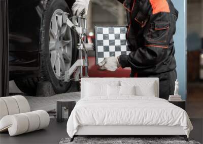 auto mechanic sets the car for diagnostics and configuration. Wheel alignment equipment on a car wheel in a repair station Wall mural