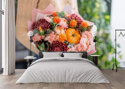 Autumn bouquet of mixed flowers in womans hands. The work of the florist at a flower shop. Fresh cut flower. Wall mural