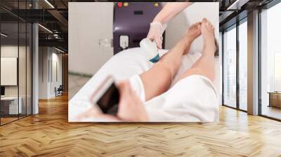 Laser epilation and cosmetology. Hair removal on ladies legs. at cosmetic beauty spa clinic. Cosmetology procedure from a therapist Wall mural