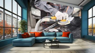 The mechanic works with a grinding tool. Sanding of car elements. Garage painting car service. Repairing car section after the accident. Wall mural