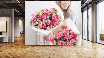 Two flowers bouquet. Sunny spring morning. Young happy woman holding a beautiful bunch of pink eustoma or Lisianthus in her hands. Present for a smiles girl. Wall mural