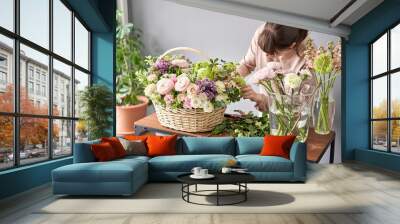 Woman florist creating beautiful bouquet in flower shop. Work in flower shop. Flowers delivery. Wall mural