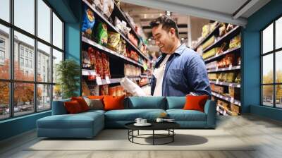 Asian man wearing medical mask shopping in supermarket. Wall mural