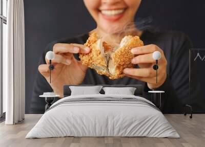 Cheerful people holding fried chicken standing over dark background with copy space. Wall mural