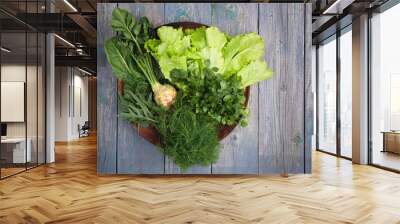 Assortment of fresh aromatic herbs on a wooden plate Wall mural